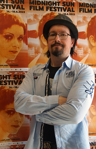 Kuva sivuston tekijästä Midnight Sun Film Festivalin julisteiden edessä